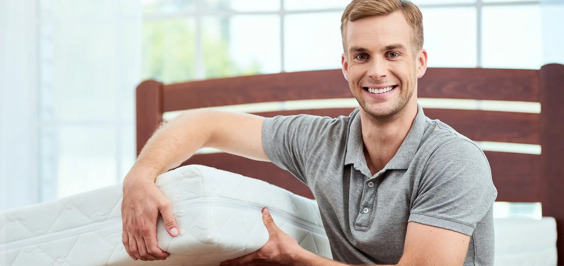 Mann zeigt eine Matratze