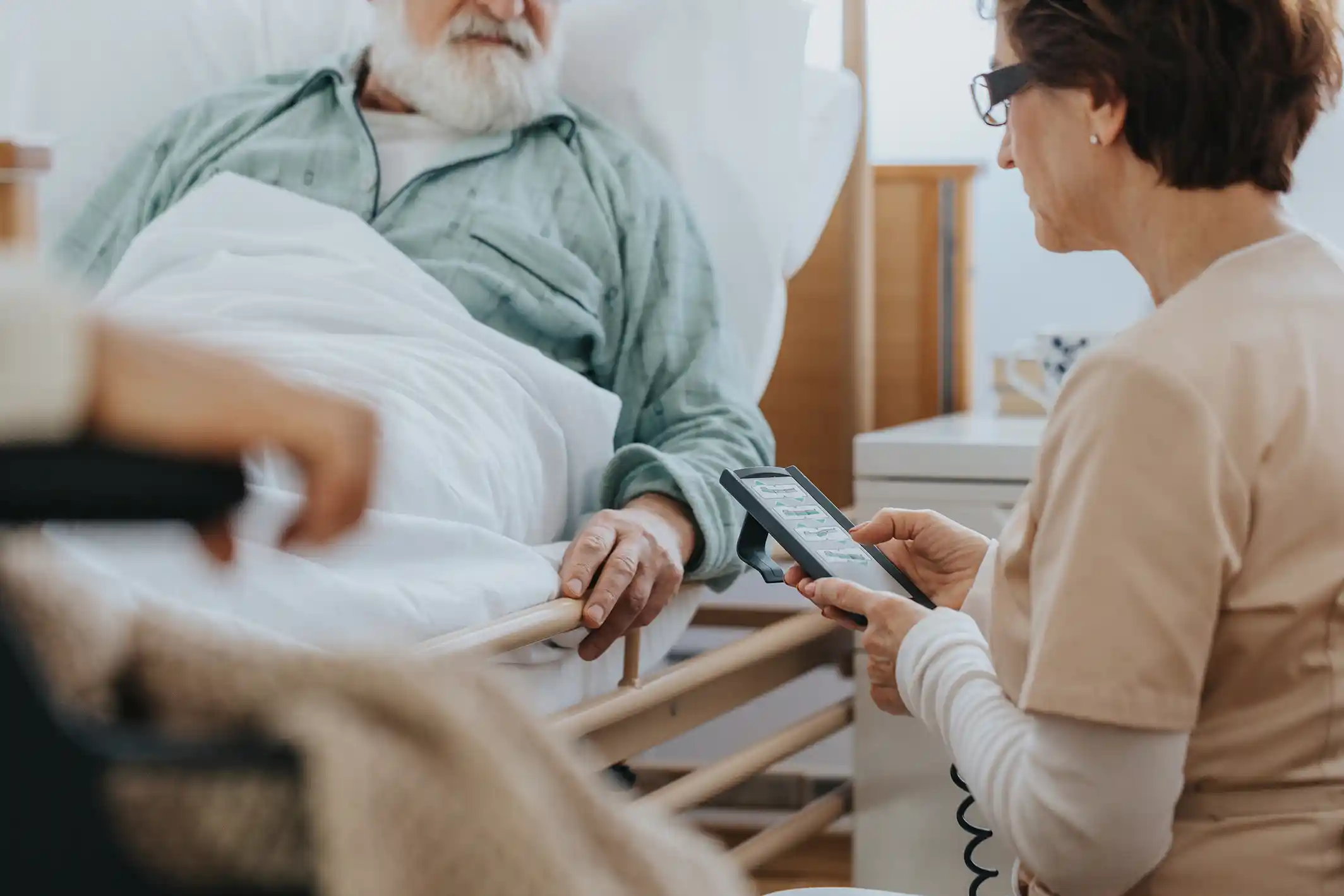 Pflegerin hilft einem Patienten.